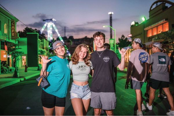 There students in Six Flags Fiesta Texas Park at dusk